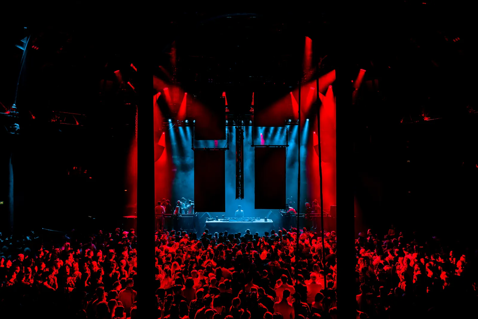 Red stage lights over a full dance floor